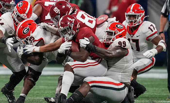 Alabama Crimson Tide running back Brian Robinson Jr. (4) is tackled by Georgia Bulldogs defensive lineman Jordan Davis (99) during the first half at Mercedes-Benz Stadium.
